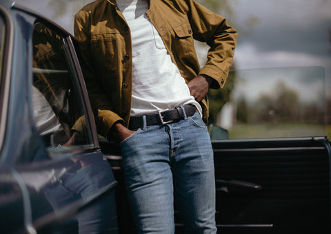 black belt with jeans outside vintage car