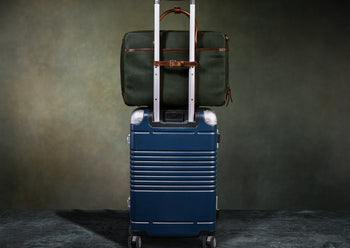 green canvas briefcase attached to luggage