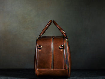side of brown leather carry on bag