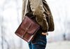 close up of brown vegetable tanned leather vertical messenger bag
