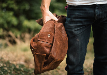 man holding brown suede jacket
